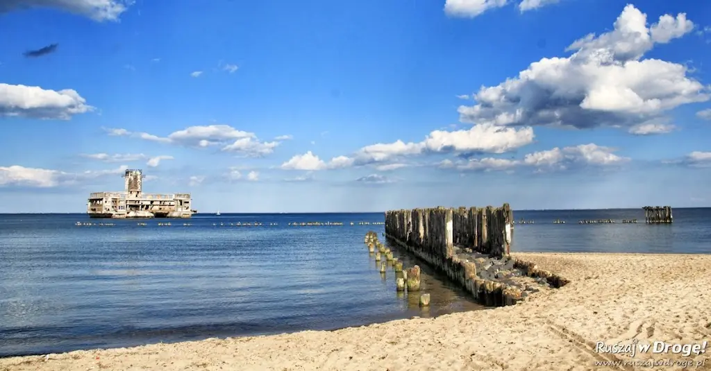 Plaża w Babich Dołach z drewnianym ostrogą i ruinami torpedowni Hexengrund w tle